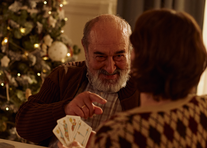 Padre e hija jugando a cartas en Navidad - Feliz Cercanía CaixaBank